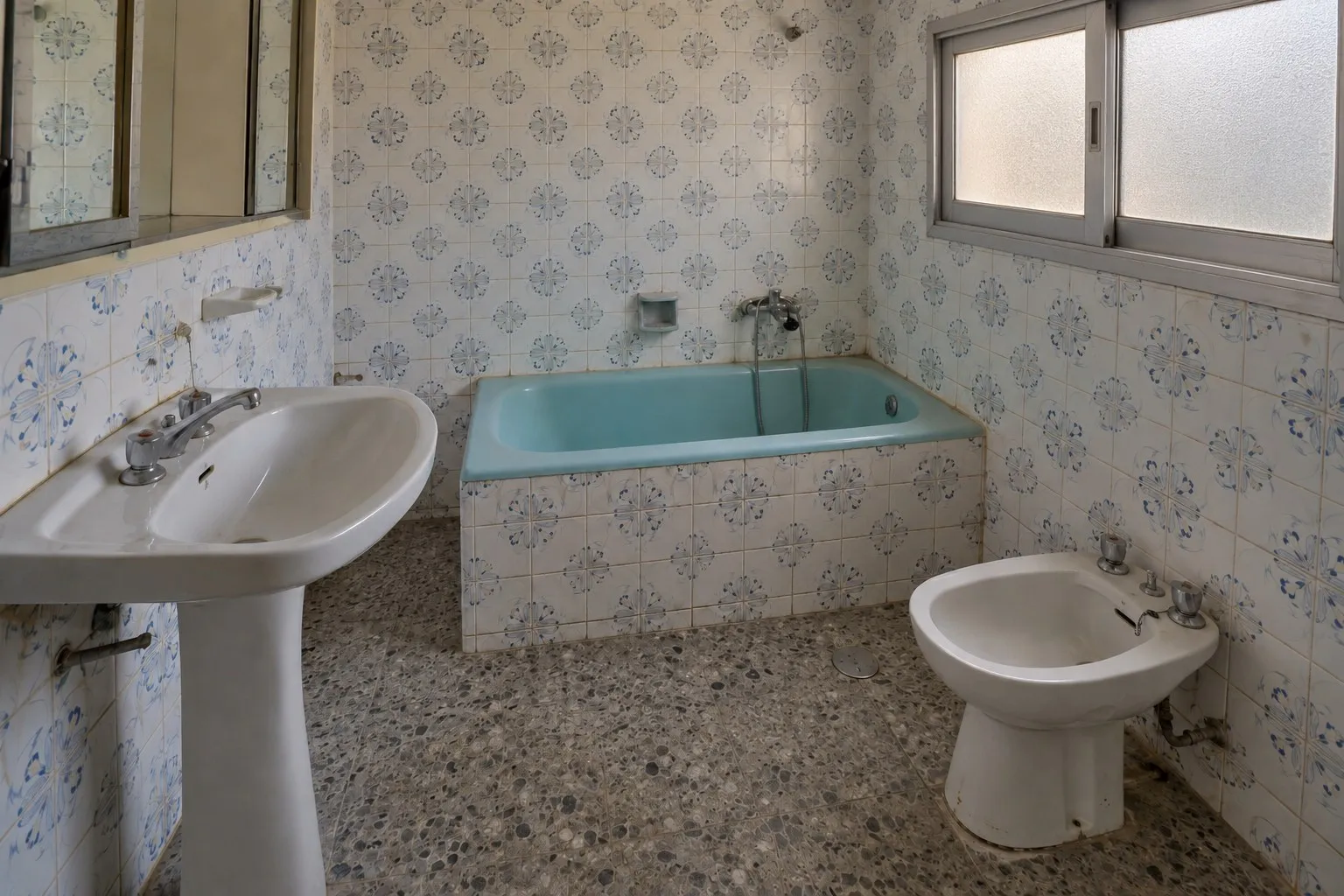 Baño de los años 70 con bañera turquesa y azulejo de flores en Arroyo de la Miel, Benalmádena, antes de la reforma