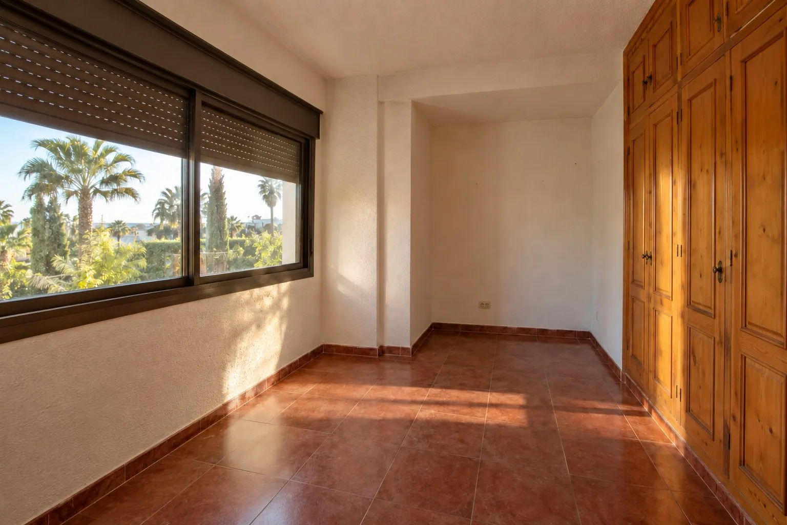 Dormitorio con baldosa rojiza y armario de pino en Torrequebrada, Benalmádena, antes de la reforma